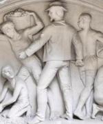 carved relief showing black slaves being driven to work by the whip